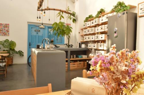 Habitación con mesa con flores y nevera. en Cantagua Hostel, en Valencia