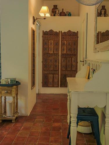 Cette chambre comprend une table blanche et une porte. dans l'établissement Montjoia, à LʼIsle-sur-la-Sorgue