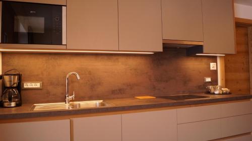 a kitchen with a sink and a microwave at Apartments Salieta in Santa Cristina Gherdëina