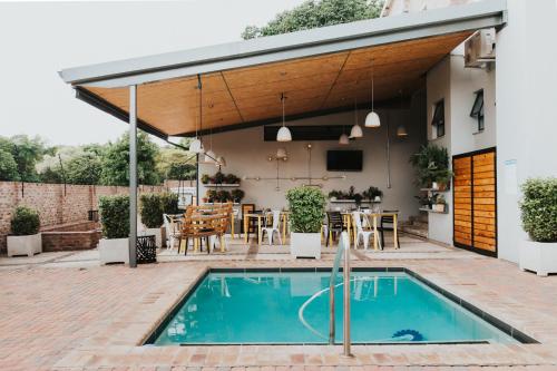 a patio with a pool and a house with awning at Execustay in Nelspruit