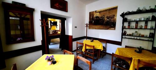 a dining room with two tables and a yellow table cloth at Penzion Na Figleně in Slatinice