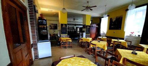 a dining room with tables and chairs and a kitchen at Penzion Na Figleně in Slatinice