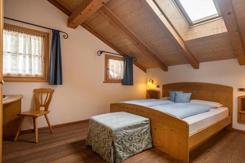 a bedroom with a bed and a wooden ceiling at Agriturismo Maso Santa Libera in Tesero