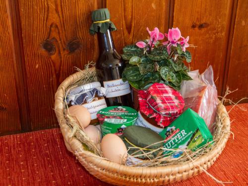 een mand met eieren en een fles bier en bloemen bij Hörlhof - Chiemgau Karte in Inzell