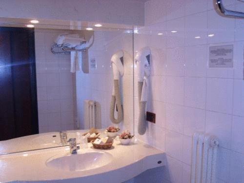 bagno con lavandino e telefono appeso al muro di Hotel Giannina a Forlimpopoli