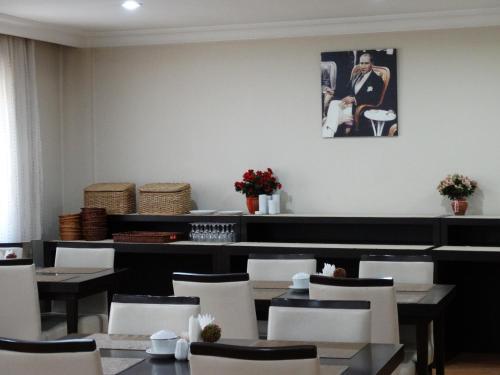 a dining room with tables and chairs and a picture on the wall at Serenti Hotel in Giresun