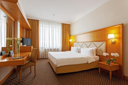 ein Hotelzimmer mit einem Bett und einem Schreibtisch in der Unterkunft Milan Hotel Moscow in Moskau