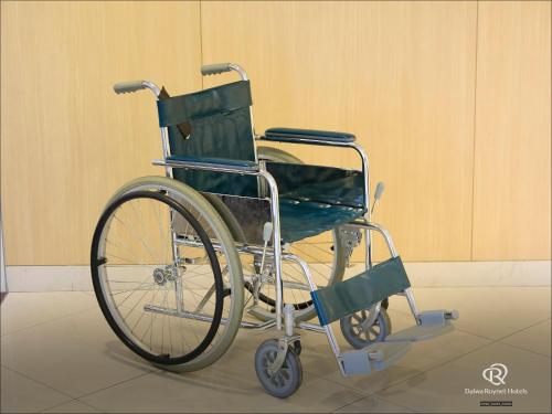 a green wheelchair is sitting in a room at Daiwa Roynet Hotel Yokohama Kannai in Yokohama
