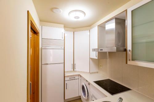 a kitchen with a refrigerator and a washer and dryer at Residencial Pinamar in Sanxenxo