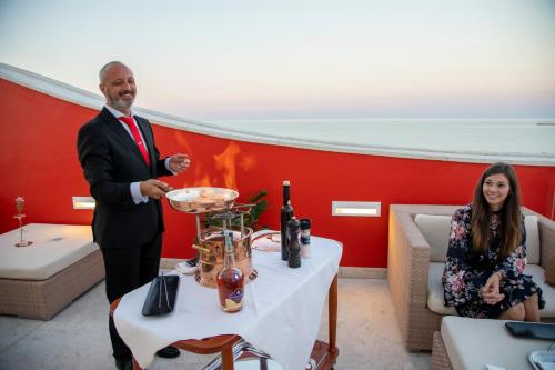 a man and woman standing at a table with a wine glass at Valentino Resort in Grottammare
