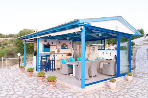 a blue pavilion with a table and chairs at Iris Villas in Spárton