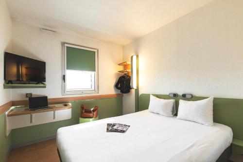 a hotel room with a bed and a television at ibis budget Lyon Centre Confluence in Lyon