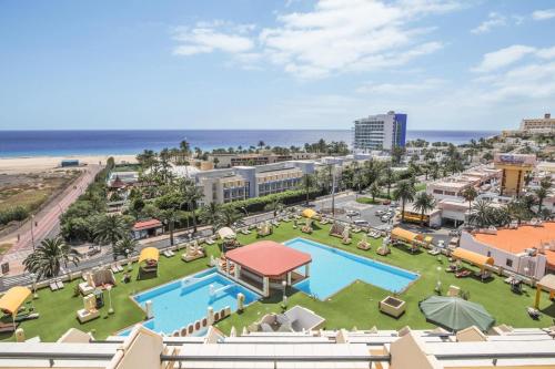 an aerial view of a resort with a swimming pool and the beach at Palm Garden in Morro del Jable