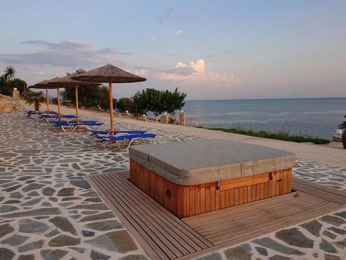 a group of chairs and umbrellas on a beach at Iris Villas in Spárton