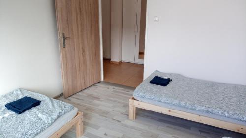 two twin beds in a room with a mirror at Apartmány Karviná in Karviná