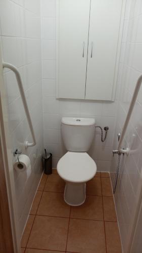 a white bathroom with a toilet with a cabinet at Apartmány Karviná in Karviná