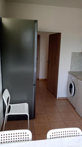 a kitchen with a stainless steel refrigerator and a washing machine at Apartmány Karviná in Karviná