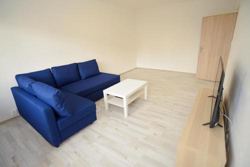 a living room with a blue couch and a table at Apartmány Karviná in Karviná