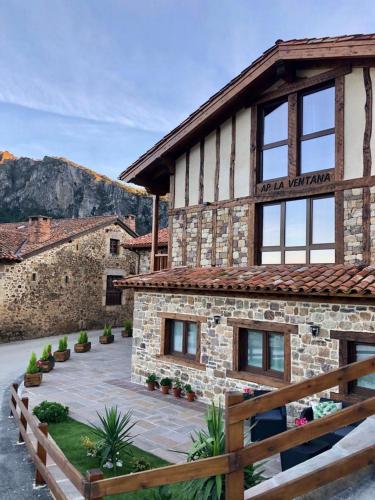 a stone building with a wooden fence in front of it at Apartamentos La Ventana de Mogrovejo in Mogrovejo