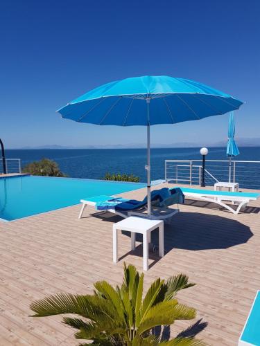 een blauwe parasol naast een zwembad bij Iris Villas in Spárton