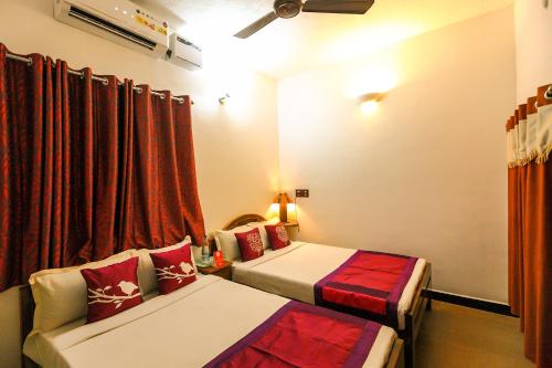 a hotel room with two beds and a window at Mermaid Island Beach Resorts in Puducherry