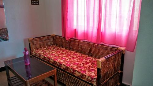 a bed in a room with a window with pink curtains at Mermaid Island Beach Resorts in Puducherry