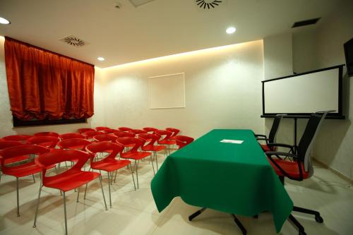 a conference room with a green table and red chairs at Grand Hotel Paradiso in Catanzaro Lido