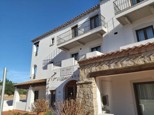 a white building with balconies on top of it at Hotel il Faro di Molara in Porto San Paolo