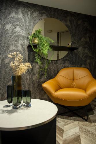 a living room with a couch and a table at Hotel - Restaurant Les 3 Piliers in Le Boupère