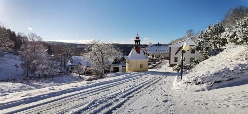 a snow covered road with a light house with a lighthouse at hotel ZLATÝ POTOK in Nicov
