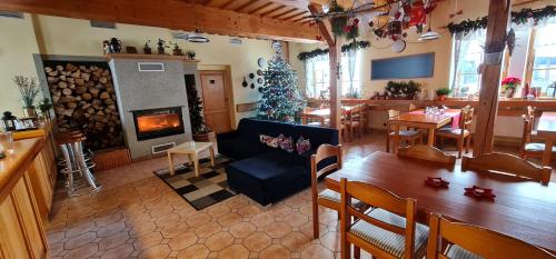 a living room with a fireplace and a christmas tree at hotel ZLATÝ POTOK in Nicov