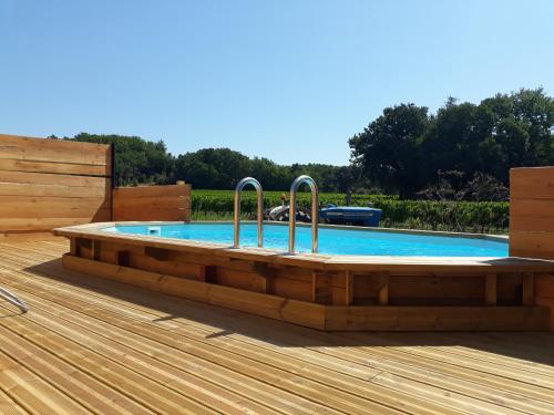 La Petite Maison Dans Les Vignes في Chamaret: حمام سباحة مع سطح خشبي وخشبي