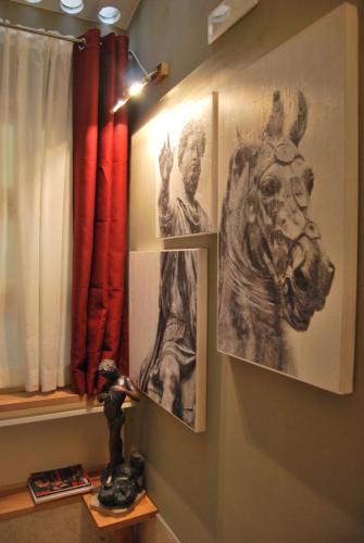 a wall with two pictures of a man and a horse at Navona Residenza de Charme in Rome