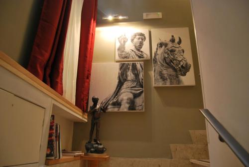 a staircase with pictures of a statue on the wall at Navona Residenza de Charme in Rome