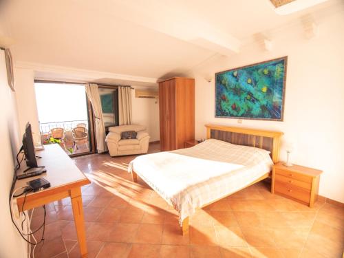 a bedroom with a bed and a desk and a television at Apartments and Rooms Levantin Inn in Sveti Stefan
