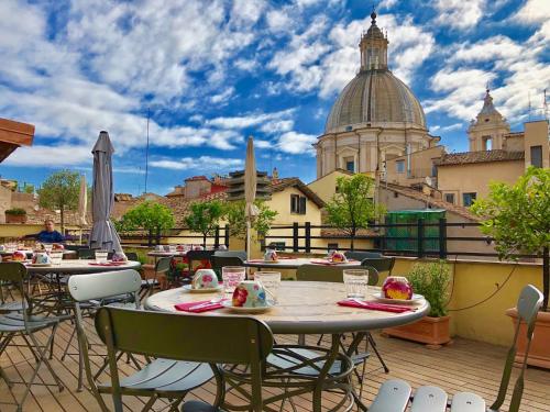 a patio with tables and chairs and a view of a city at Navona Residenza de Charme in Rome