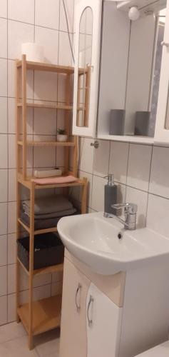 ブダペストにあるLaky9 Apartmanのバスルーム(シンク、鏡、棚付)