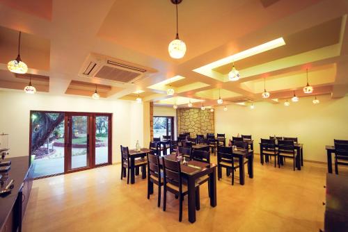 um restaurante com mesas e cadeiras de madeira em uma sala em Tranquil Resort & Spa em Mahabaleshwar
