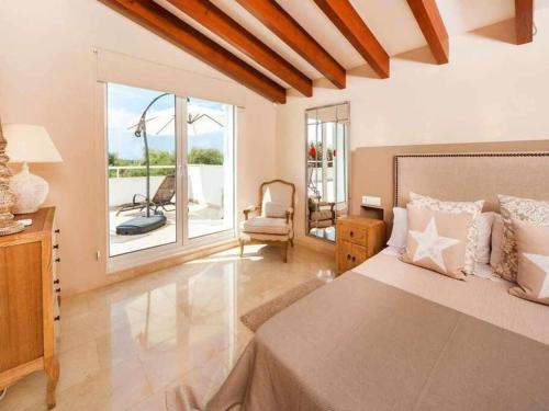 1 dormitorio con 1 cama, 1 silla y 1 ventana en Villa Bini Xoroi Fabulosa propiedad para grupos, en Binibeca