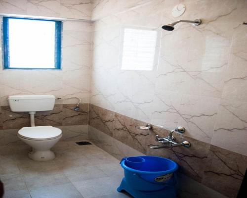 baño con aseo y cubo azul en Hotel Govindpuram, en Kolhapur