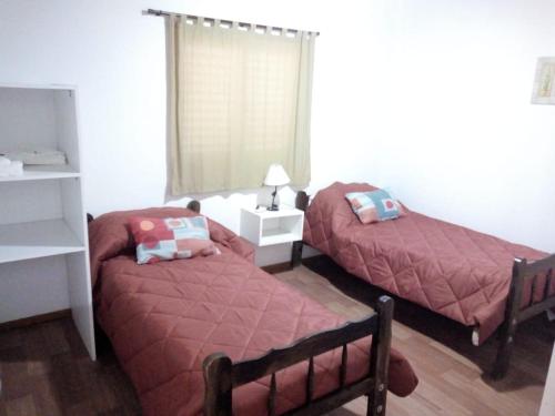 a bedroom with two twin beds and a window at APART Hotel APH in Reconquista