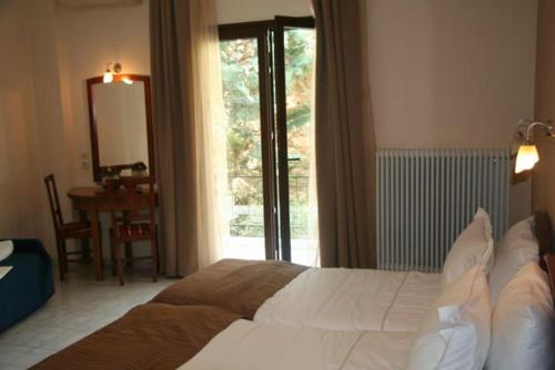 1 dormitorio con cama, mesa y ventana en Villa C & C, en Delfos