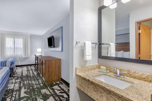 a hotel room with a bathroom with a sink at AmericInn by Wyndham Pella in Pella