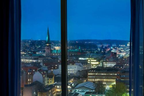 a view of a city at night from a window at Comwell Aarhus Dolce by Wyndham in Aarhus
