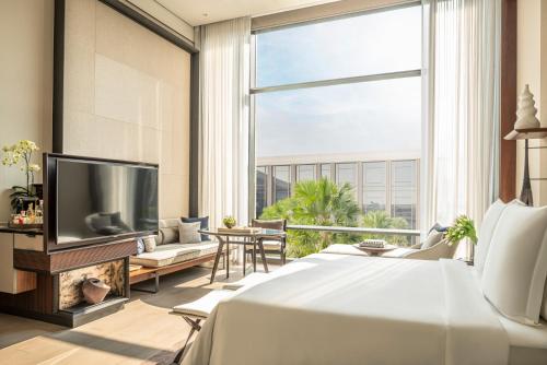 a bedroom with a bed and a large window at Four Seasons Hotel Bangkok at Chao Phraya River in Bangkok