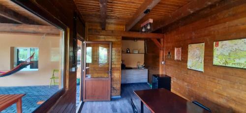 a room with wooden walls and a wooden table and a door at River Star in Sîngeorgiu de Pădure