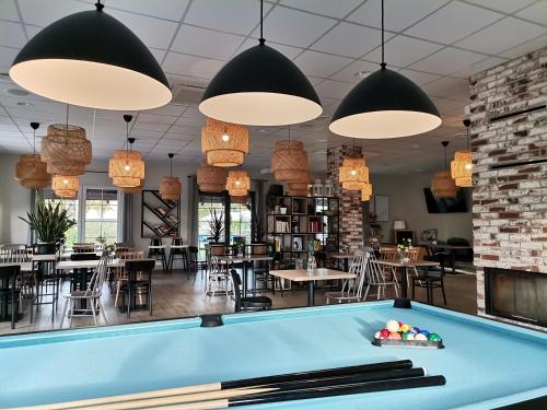 a pool table in a restaurant with tables and chairs at Tulipanowy Gościniec in Jantar