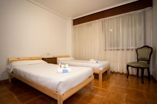 フェロルにあるTuristiQA - Piso Carballo Ferrol VUTCO01445のホテルルーム ベッド2台&椅子付