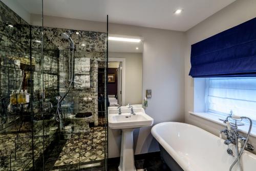 a bathroom with a tub and a sink and a shower at The Castle Inn in Harrogate