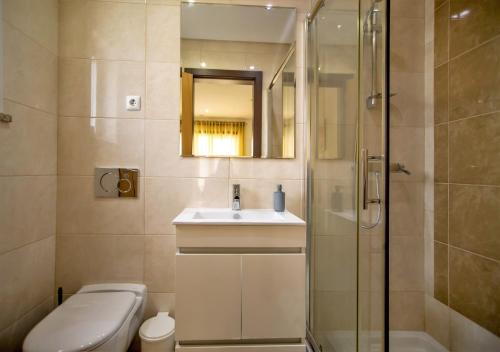 a bathroom with a toilet and a sink and a shower at Villa Rafaella II Palace by Atlantic Places in Albufeira